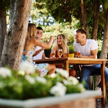 Group of friends eating at a picnic table.